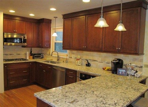 Cambria Praa Sands Engineered Stone with Autumn Glazed Cherry Cabinets, Limestone Subway Tile and Red Oak Flooring